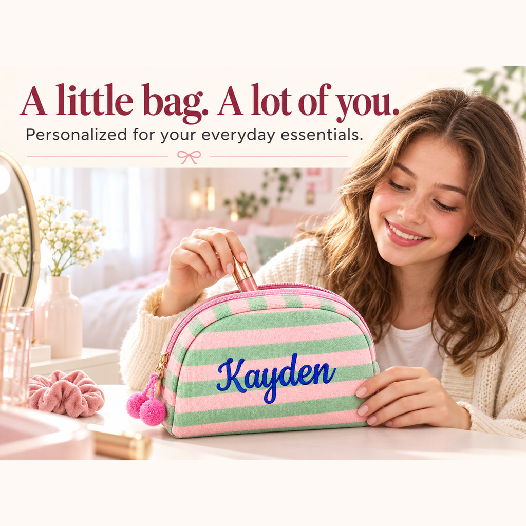 Model using a Sage and Pink striped makeup bag with example name Kayden embroidered in blue, showing everyday beauty storage. Styling props are not included.