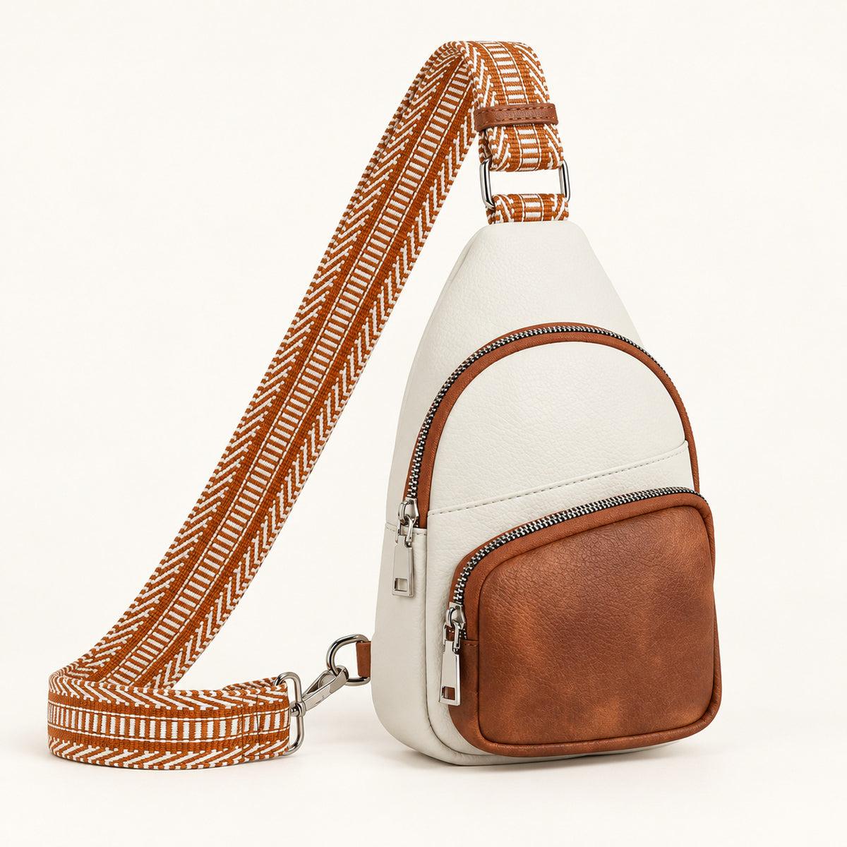 Cream and Cognac sling bag with an ivory body, cognac zipped front pocket and rust and ivory geometric woven strap.