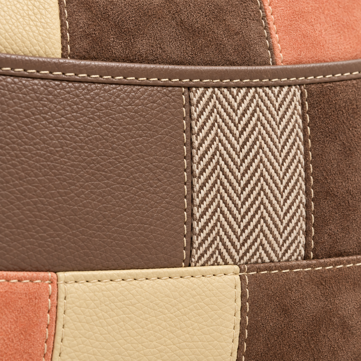 Close-up of cream contrast stitching, textured taupe and apricot patchwork panels, and woven herringbone detail.