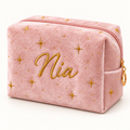Blush pink velvet makeup bag with gold stars and example embroidered name Nia.